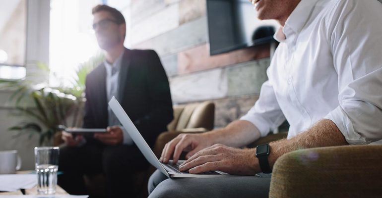 business men in meeting with laptops